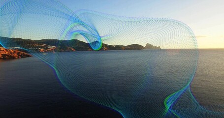 Obraz premium Flowing digital mesh wave overlay sweeping across seaside at sunset with rocky coastline and hills
