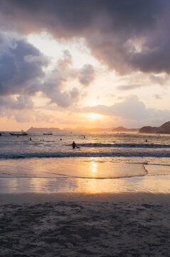 Surfers in the water at sunset, Selong Belanak Beach, Lombok
