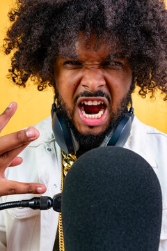 Angry man shouting into microphone wearing headphones