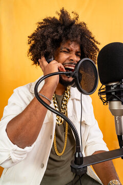 Young black man passionately performing music in recording studio