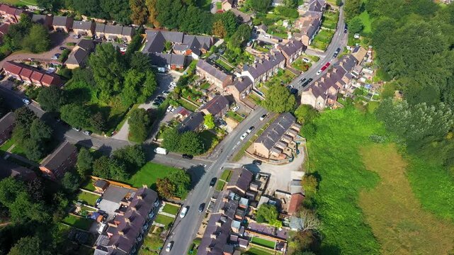 Aerial drone footage of the village of Ripon in North Yorkshire in the UK showing the historic British village and streets full of rows of terrace houses from above on a sunny day in the summer time