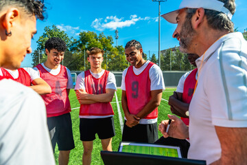 Soccer coach explaining strategy to young team players