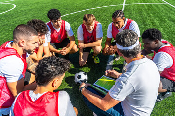 Soccer coach explaining strategy to diverse team players