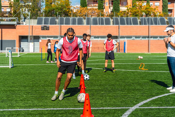 Young men training football agility drills on a field