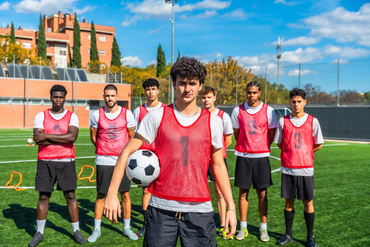 Young soccer team standing on field with ball