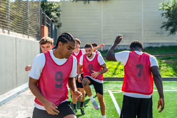 Male soccer players training on field, practicing drills