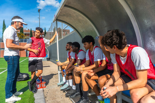 Coach instructing young soccer team during halftime break