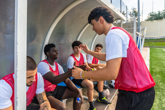 Soccer players shaking hands in team dugout
