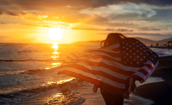 Happy woman running on beach while celebrating independence day and enjoying freedom in USA - Powered by Adobe