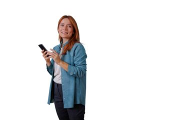 Redhead woman smiling, looking up and holding smartphone, texting and communicating on mobile device