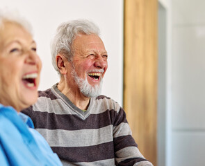 Happy active senior couple, portrait of an elderly woman with her husband sitting at home