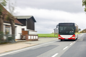 Fototapeta premium City bus on rural road. Public transport in motion.