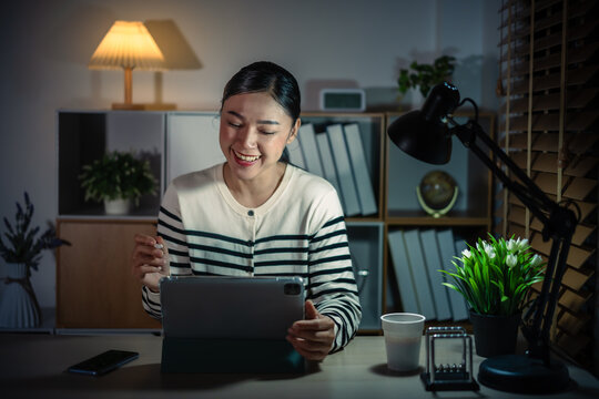 happy woman working with digital tablet at a night