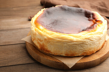 Tasty Basque cheesecake on wooden table, closeup