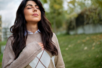 Relaxed woman breathing fresh air outdoor in the autumn 