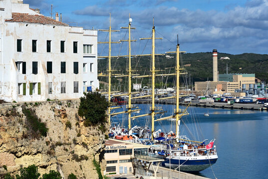 Ma&oacute;, Mah&oacute;n, Menorca, Balearic Islands, Spain, Europe - 10.2025 :  Mah&oacute;n Harbour, Royal Clipper - largest five masted square sail sailing ship, Star Clippers Company, CEMEX cement industrial plant
