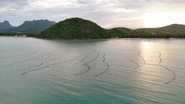 Coastal fishing nets in the sea seen from drone view at sunset