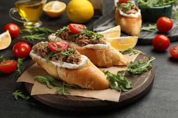 Delicious bruschettas with tuna, cream cheese and tomatoes on grey table, closeup
