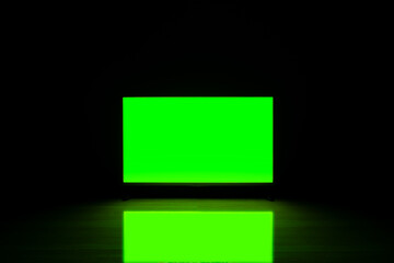 4K LCD, television cut chroma key green screen, with reflected in a glossy floor in dark room.