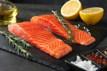 Pieces of salmon fillet and spices on grey table, closeup