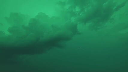 A stormy sky scene, with clouds and a lightning bolt in green hue