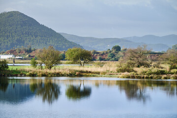 Person walking along tranquil mountain lake landscape