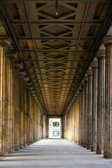 Classical colonnade with rhythmic coffered ceiling and deep perspective. Stone symmetry.