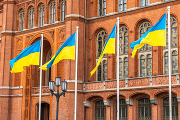 Ukrainian flags waving before historic architecture. Symbol of unity and dignity.