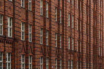 Brick facade with rhythmic windows and decorative masonry. Modular pattern.