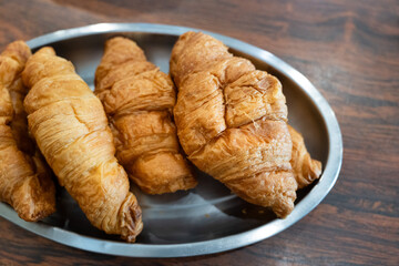 Freshly baked croissants on a metal plate