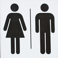 Simple black and white restroom sign showing male and female symbols separated by a line. Minimalist pictogram design commonly used to indicate public toilets or washrooms. 