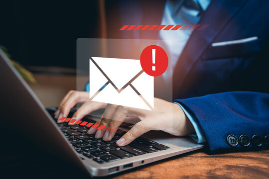 Email alert notification concept. Businessman typing on laptop with red warning icon for spam, data breach, phishing, or security threat in online communication