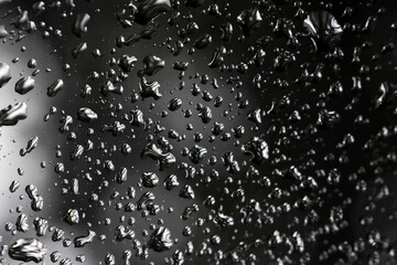 Moody abstract background of water drops on wet black surface. liquid texture of rain creates calm and reflective pattern full of moisture and condensation