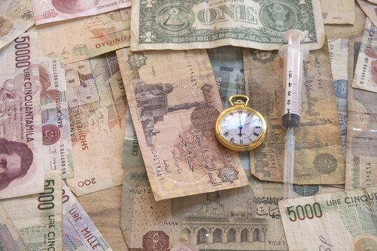 time money and healthcare concept with syringe and world currencies
