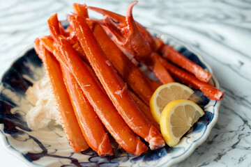 Steamed snow crab legs with lemon slices on a decorative plate