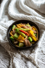 Colorful stir fried vegetables in a dark bowl