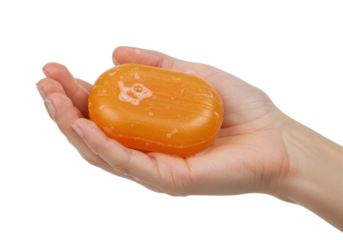 Isolated orange bar of soap resting in a human hand for hygiene and cleanliness needs