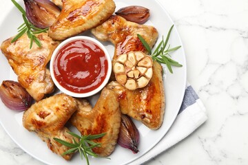 Delicious grilled chicken wings served on white marble table, top view. Space for text