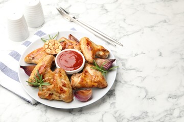 Delicious grilled chicken wings served on white marble table. Space for text