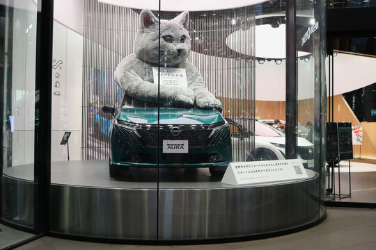 TOKYO, JAPAN - November 1, 2025: A Nissan Note Aura with a 3-meter tall cat on its roof on display at Nissan Crossing in Ginza.