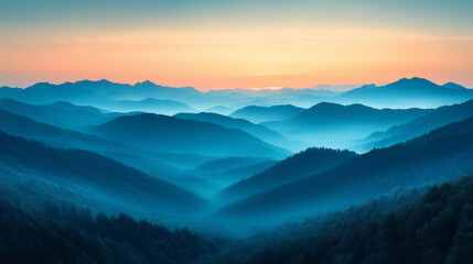 Obraz premium Misty Mountain Range at Sunrise with Atmospheric Hues of Blue and Orange