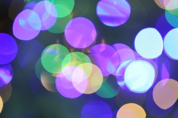 Beautiful blurred Christmas lights on color background, closeup. Bokeh effect