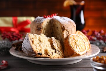 Christmas food. Delicious Panettone cake and festive decor on wooden table, closeup