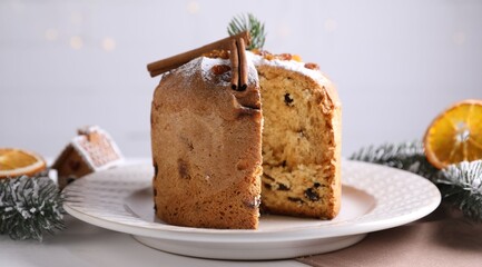Christmas food. Delicious Panettone cake and festive decor on white wooden table against background with blurred lights, closeup