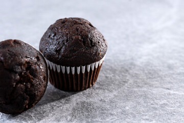 Homemade chocolate muffins pn gray stone background. Copy space