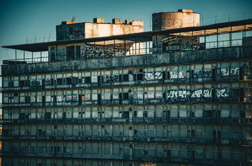 Obraz premium Abandoned Brutalist Structure Graffiti and Decay on a Derelict Concrete Building