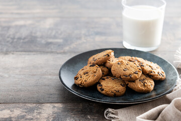 Chocolate chip cookies and milk for breakfast on wooden table. Copy space