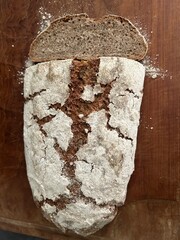 freshly baked sourdough bread sliced on wooden cutting board, directly above