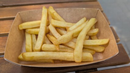Freshly prepared golden fries in rustic outdoor cafe setting