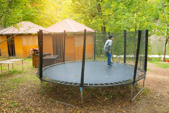 Boy is jumping trampoline in the park.
